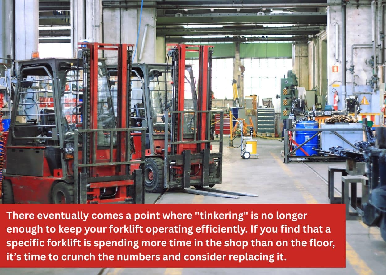 Multiple forklifts parked inside an industrial warehouse maintenance area ready for inspection or repair.